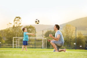 Father and son playing soccer